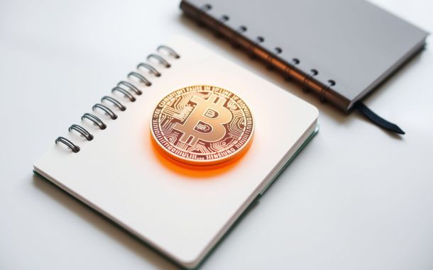 Abstract representation of secure cryptocurrency assets alongside a notebook, symbolizing how to secure your cryptocurrency.