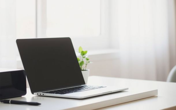 Laptop and plant on a bright desk representing affiliate marketing strategies for passive income generation online.