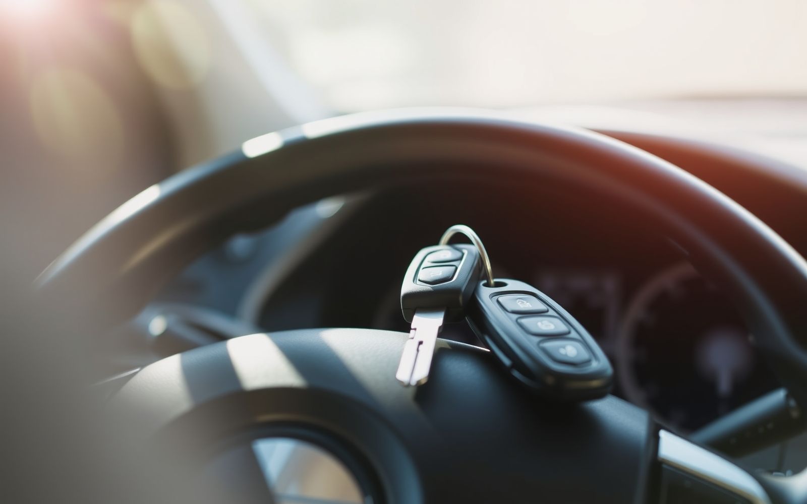 Car key on steering wheel, representing car insurance quotes comparison