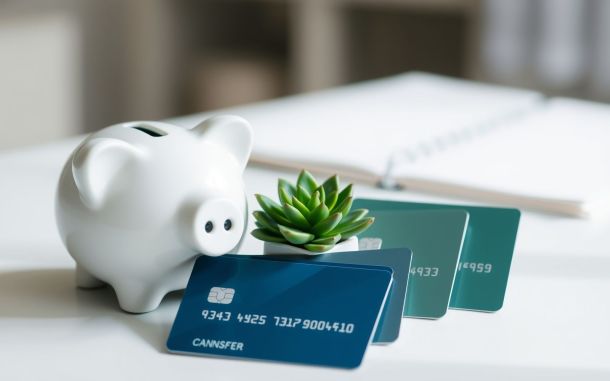 Piggy bank and credit cards illustrating the financial benefits of using a balance transfer credit card.