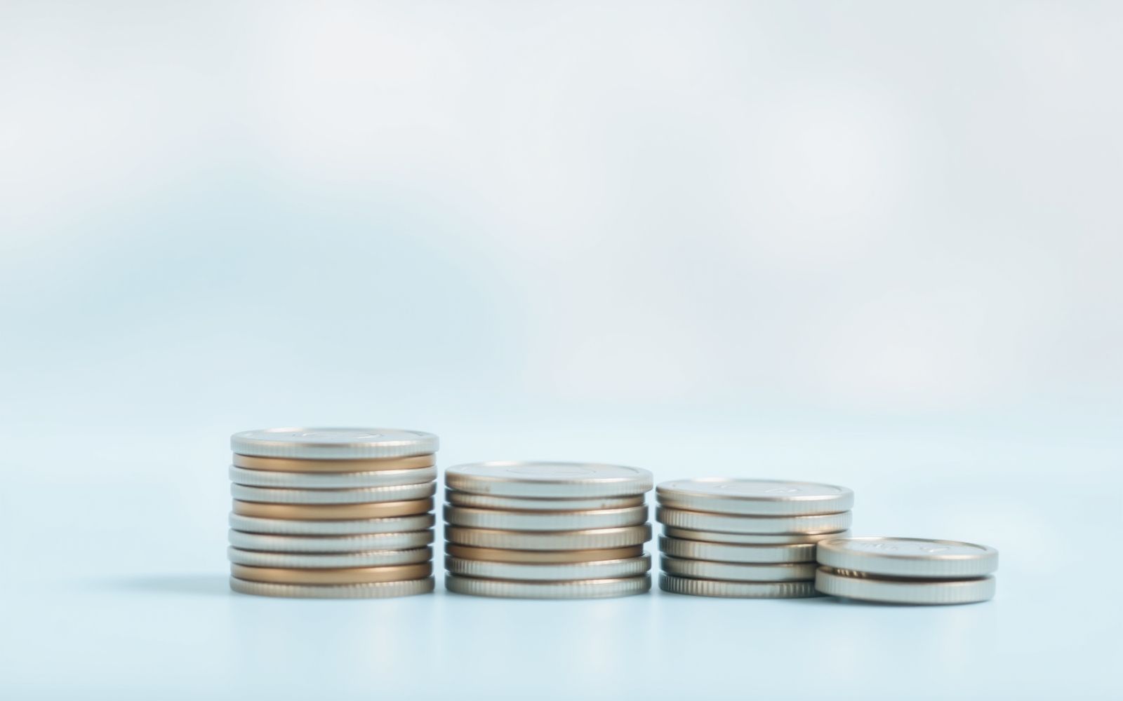 Abstract image depicting inflation with a stack of coins decreasing in size, symbolizing diminishing purchasing power.